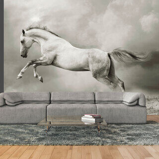 Fototapet - Stark hingst - vit hoppande häst på sanden i en grå dimma